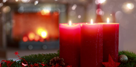 Glowing Advent candles and fireplace in blurred backgroundの写真素材