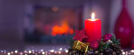 Glowing Advent candle and fireplace in blurred backgroundの写真素材
