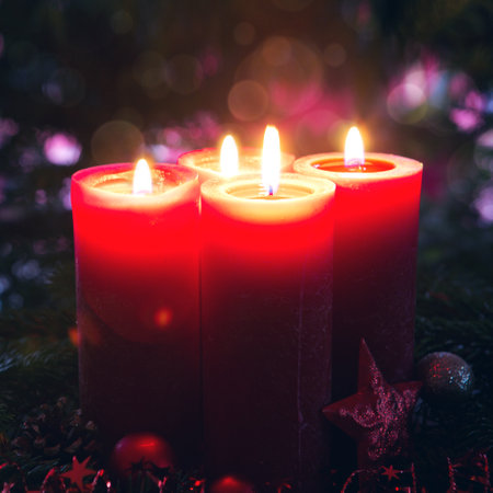 Glowing Advent candles on black blurred backgroundの写真素材