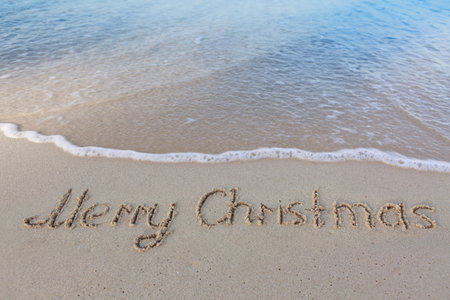 Merry Christmas handwriting in the white Caribbean sand.