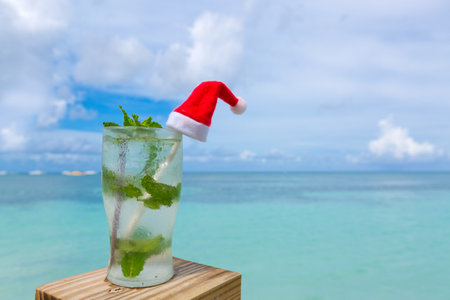 Christmas background with drinks Bocal with Santa hat on Caribbean beach.の写真素材