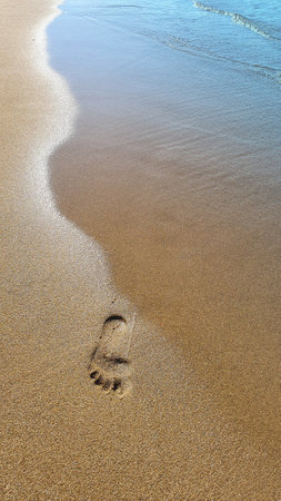 Footprints on tropical beach and beautiful waveの写真素材