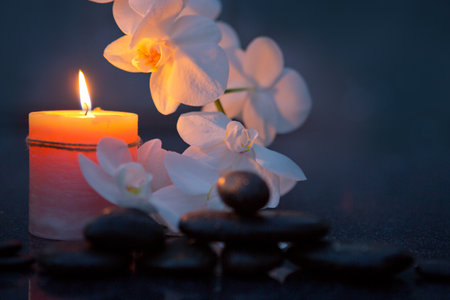 Spa background with white orchid , candle and zen black stones on gray.の写真素材