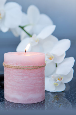 Spa background with white orchid , candle and zen black stones on gray.の写真素材