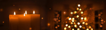 Golden Advent candles isolated on blurred glowing Christmas tree backgroundの写真素材