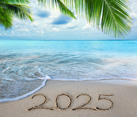 New Year 2025 background with hand written in the white sand.の写真素材