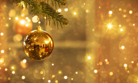 Christmas tree branch with golden ball and blur background.の写真素材