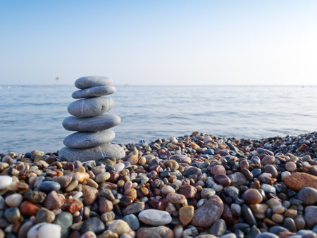 Spa stones balance on the sand of the beach.の写真素材