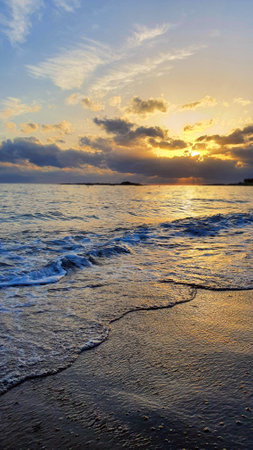 Sunset sky over sea in the evening with colorful clouds and warm sunlightの写真素材