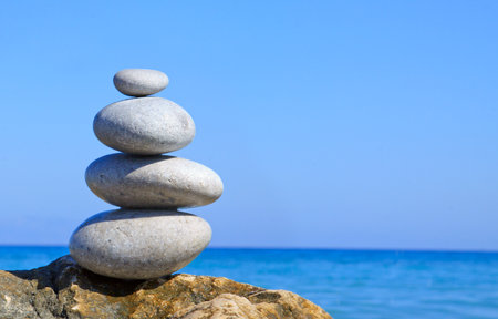 Pyramid spa stones on the seashore on a sunny day on the blue sea background.の写真素材