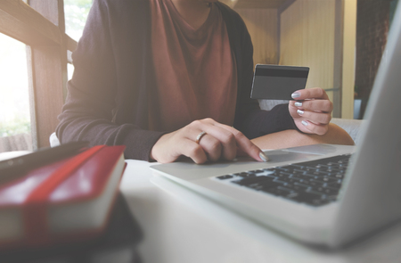 Young woman holding credit card and using laptop computer. Online shopping conceptの写真素材