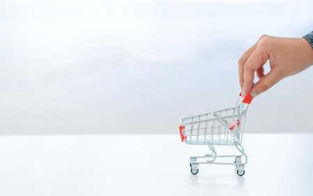female hand holding shopping cart trolleyの写真素材
