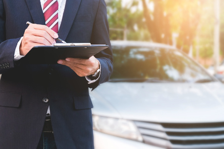 An insurance expert employee working with a car at outdoorの写真素材