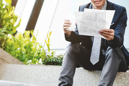 businessman sit and reading data resource outdoor with coffee.の写真素材