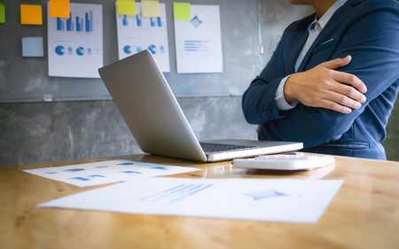 Businessman working with documents on a table and laptop in a modern officeの写真素材