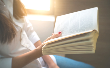 young woman reading a book at home.の写真素材