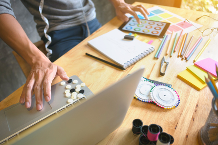 creative / fashion designer working on laptop and digital tablet at modern home studioの写真素材