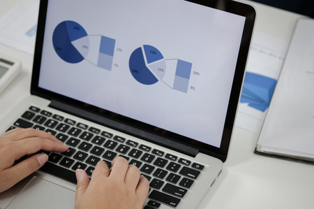 business woman using laptop with financial number in workplace.の写真素材