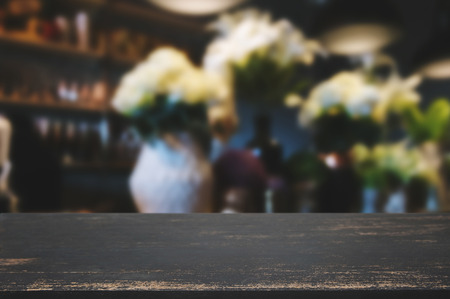 blank wooden table with blurred montage coffee shop cafe backgroundの写真素材