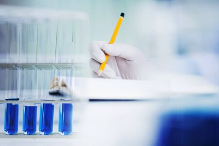 close up hand of medical chemist / scientist student  experiments test tube in laboratory, selective...