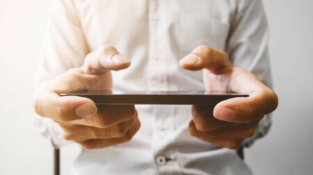 hands of man watching mobile smart phone - device technology and gadget concept