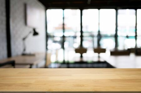 empty wood table desk in front of blurred coffee shop cafe backgroundの写真素材