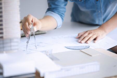 interior Architect working on blueprint with engineering tools