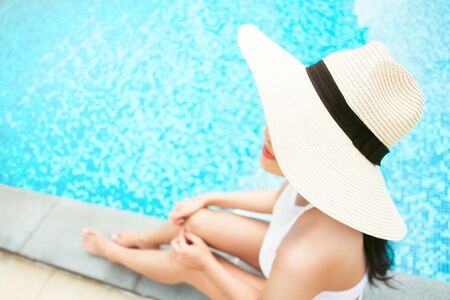 travel and vacation concept - close up of young woman relaxing at a pool in summer, selective focusの写真素材