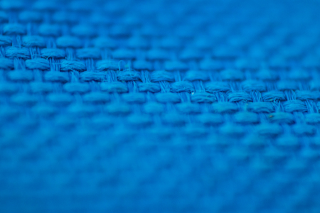 a macro shoot of braided blue cloth texture with vivid colors. focus on mid of picture.