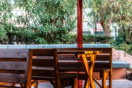 some wooden chairs and table has set like a cafe in a residental area. photo has taken at...