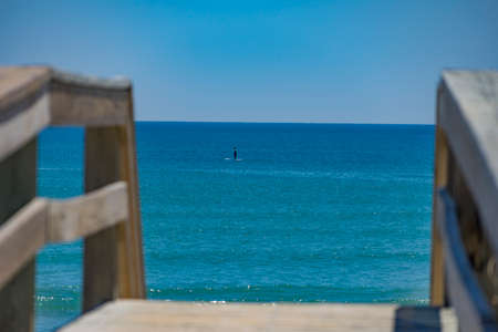 A Lone Paddleboarder enjoyes the perfect weather at the beachの写真素材