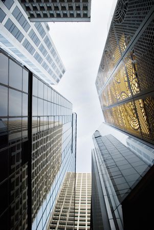 looking up into the many buildings that frame Hong Kongs skyline, framing the sky and reflecting the...