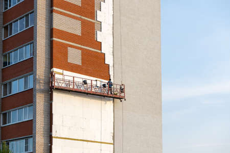 Building the cradle with the workers, repair of a facade of Russia