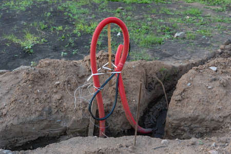 Ribbed red plastic pipes containing electric cables for lighting.