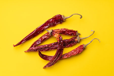 Dry red pepper pods on yellow backgroundの写真素材