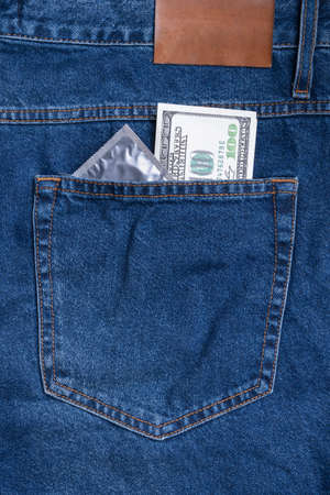 A hundred dollar bill and a condom in the back pocket of my jeans. Vertical photoの写真素材