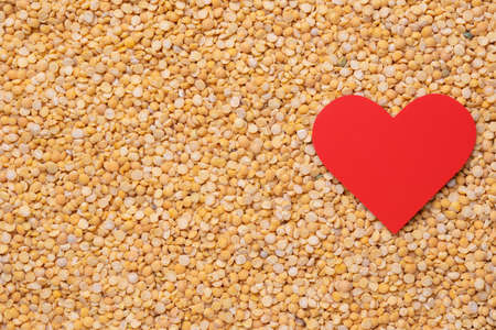 Red heart on a background of dry peas. Copy-spaceの写真素材