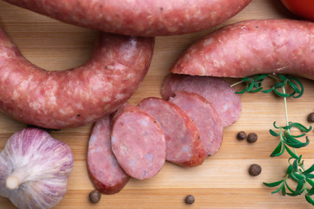 Sliced homemade sausage on a cutting board, top-view