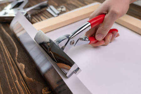Hand with a tool for stretching the canvas. The business of producing paintings on canvas from photographsの写真素材