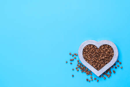 Buckwheat in the shape of a heart on a blue background. Silver heart.の写真素材
