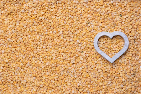 Silver heart on a background of dry peas. Copy-spaceの写真素材