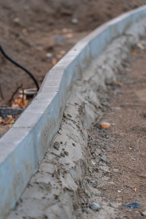 Installation of curbs at the construction site. Curved line road curb, selective focusの写真素材