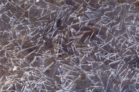 The texture of ice congealed on top of the ground. Frozen puddle in winterの写真素材