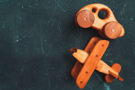 Wooden toy car and biplane on a dark background, top viewの写真素材