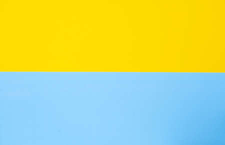 Yellow-blue background bisected vertically. Blue and yellow sheet of paper, copy-spaceの写真素材