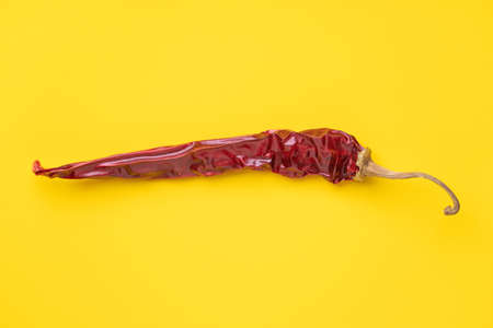 Pod of dry hot red pepper on yellow background, horizontal photoの写真素材