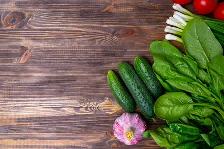 Fresh green vegetables on brown wooden background, top viewの写真素材