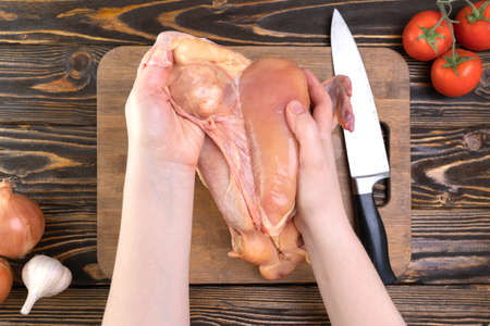 The chef's hands peel off the skin from the chicken breast. Chicken filletの写真素材