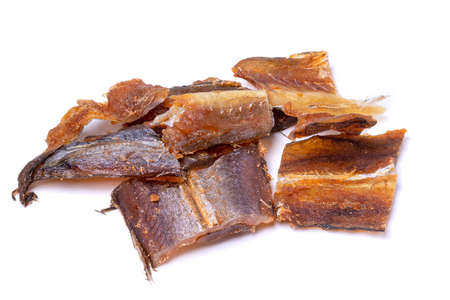 Pieces of salted dried fish with spices isolated on a white background