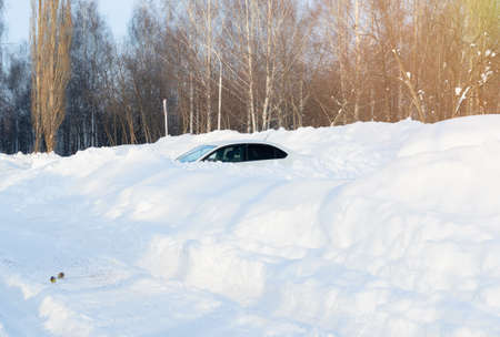 A snowstorm, cars parked among huge snowdrifts.の写真素材